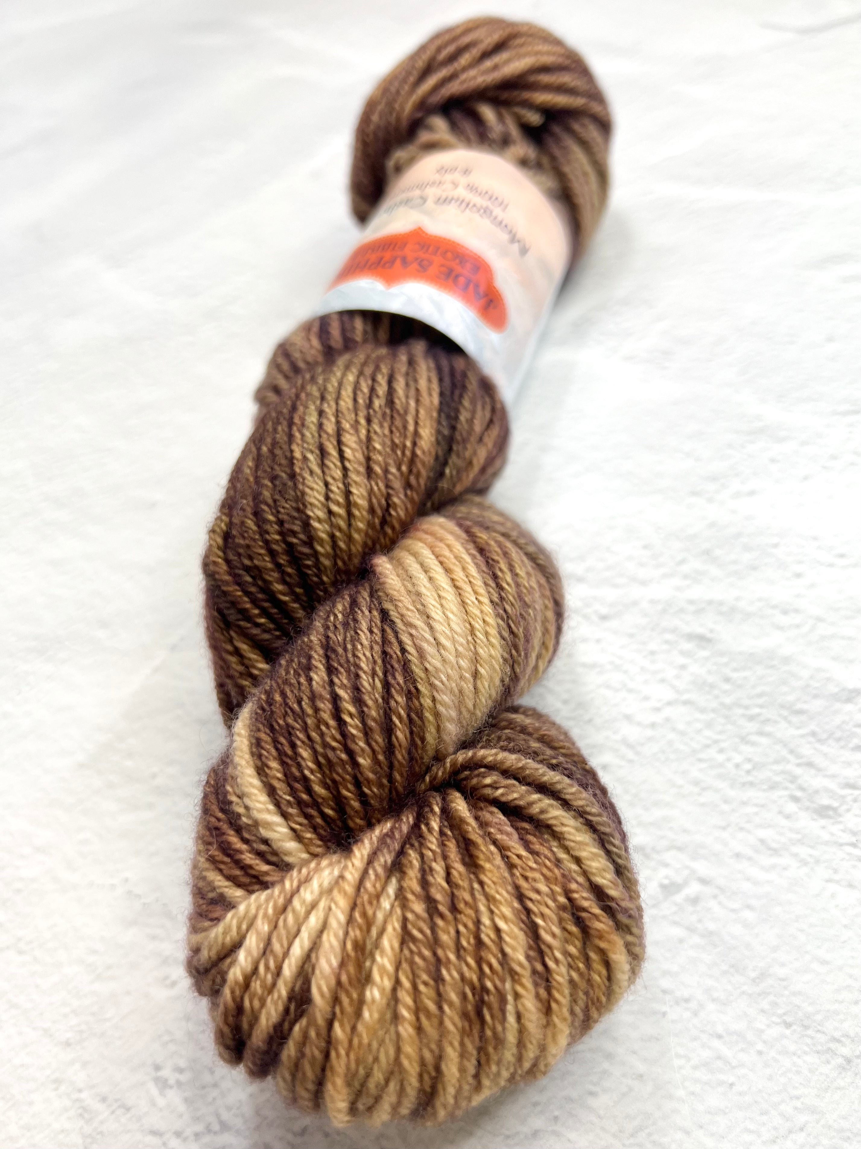 Jade Sapphire 8 Ply Cashmere yarn in a natural cream color, showing soft, luxurious cashmere fibers perfect for knitting or weaving.