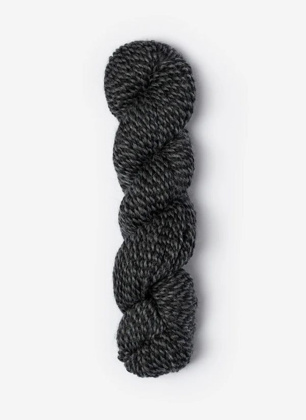 Blue Sky Fibers Baby Alpaca Sport Weight Melange alpaca yarn skein in soft blue and gray tones with label visible.