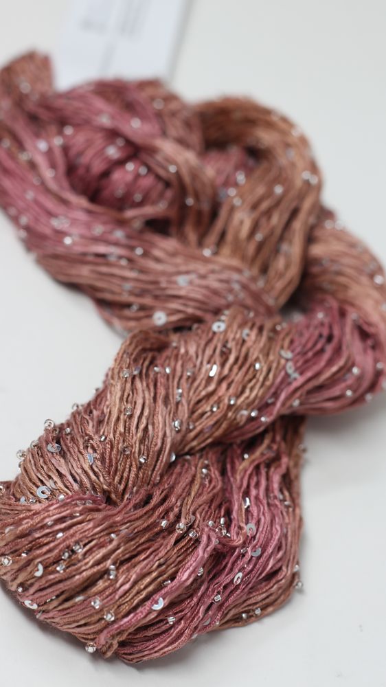 Artyarns Beaded Silk & Sequins Light beaded yarn with shimmering sequins and silk fibers, shown in a close-up view.