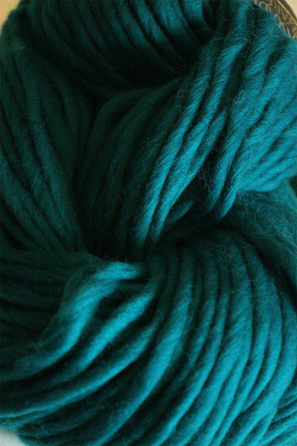 Cascade Yarns Magnum bulky yarn in a vibrant blue color, showcasing thick, soft fiber suitable for cozy knitting projects.