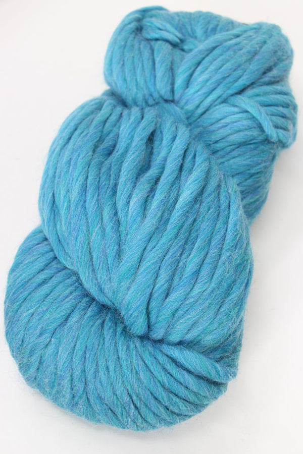 Close-up of Cascade Yarns Magnum bulky yarn in a skein, showcasing thick, soft, and textured yarn for knitting or crochet projects.