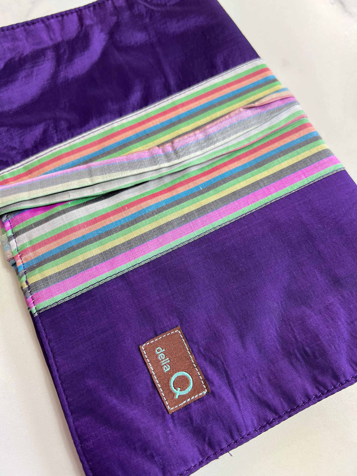Della Q double point knitting needle case with purple stripe fabric, designed to hold and organize knitting needles.