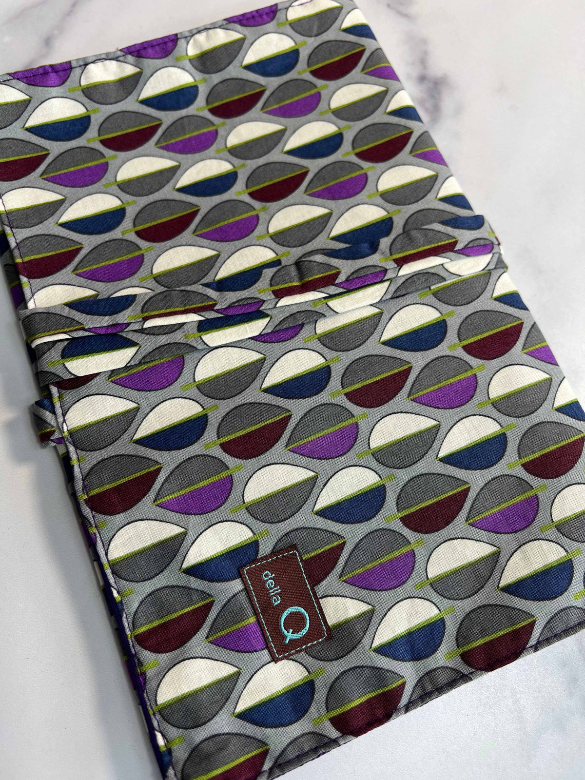 Della Q double point knitting needle rollup case with organized slots, made of fabric, for storing knitting needles.