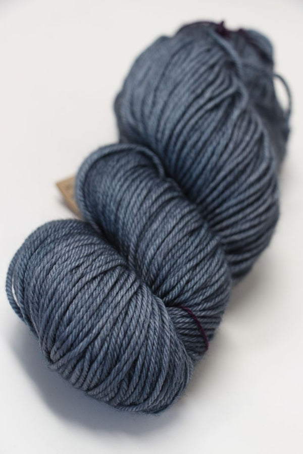 Madelinetosh Tosh DK yarn in a deep rust color, soft and thick-dyed wool for knitting and crochet projects.