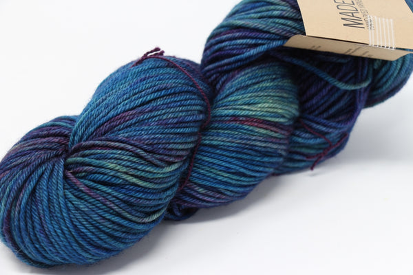 Madelinetosh Tosh DK yarn in vibrant Mandala colorway, soft wool for knitting and crochet projects, close-up of yarn skein.