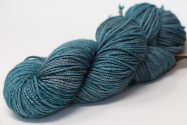 Madelinetosh Tosh DK yarn in a rich, deep color, showcasing its soft, twisted fiber texture suitable for knitting or crochet projects.