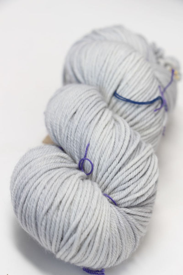 Madelinetosh Tosh DK yarn in Silver Fox color, showing a close-up of soft, hand-dyed wool yarn with subtle gray tones.