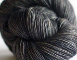 Madelinetosh Tosh DK yarn in leopard print with tan and black tones, showcasing soft, twisted fiber strands for knitting or crocheting.