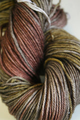 Madelinetosh Tosh DK yarn in Woodstock colorway, showing soft wool skein with rich, warm tones and subtle color variations.