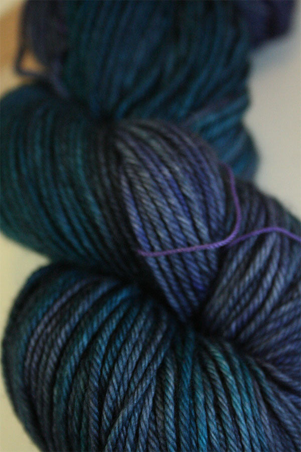 Madelinetosh Tosh DK yarn in a soft, vibrant colorway, showcasing the twisted skein's texture and rich fiber quality.