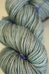 Madelinetosh Tosh DK yarn in Fallen Cloud color, soft wool fiber, shown in a close-up with vibrant, variegated blue and gray tones.