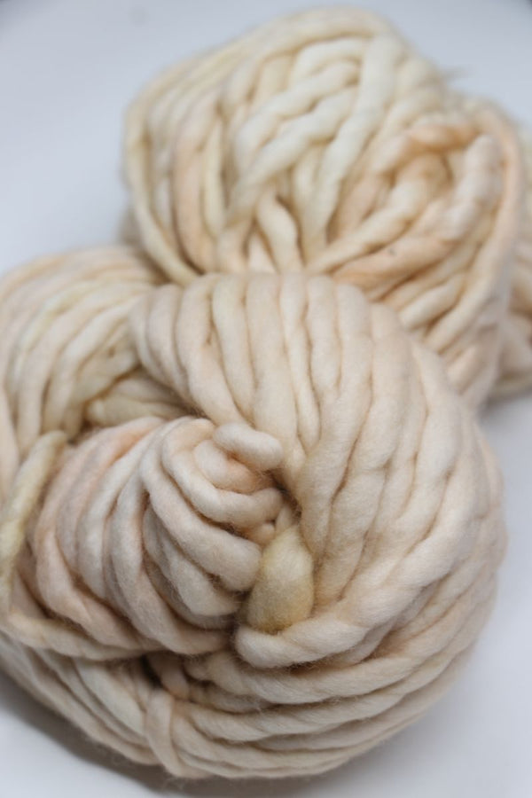 Light ivory Malabrigo Rasta merino wool yarn skein, soft and textured for knitting or crocheting projects.