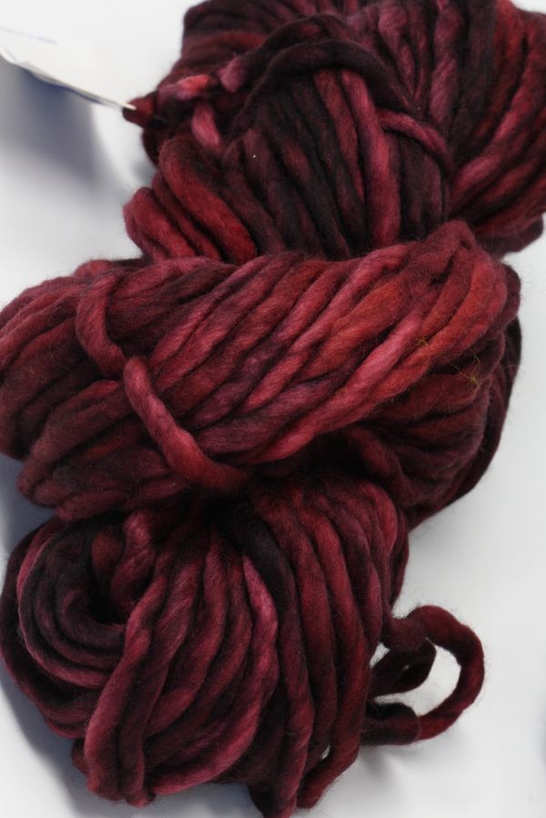 Malabrigo Rasta merino wool yarn in vibrant red, showcasing thick, soft, and textured knitting or crochet stitches.