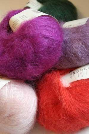 Colorful skeins of Rowan Kidsilk Haze yarn arranged in a group shot, showcasing soft, lightweight knitting and crochet material.