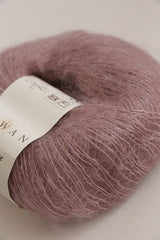 Close-up of Rowan Kidsilk Haze yarn in soft, multicolored strands, showcasing its lightweight, delicate texture for knitting or crochet projects.