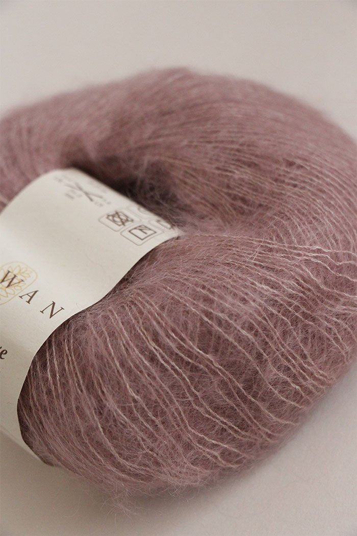 Close-up of Rowan Kidsilk Haze yarn in soft, multicolored strands, showcasing its lightweight, delicate texture for knitting or crochet projects.