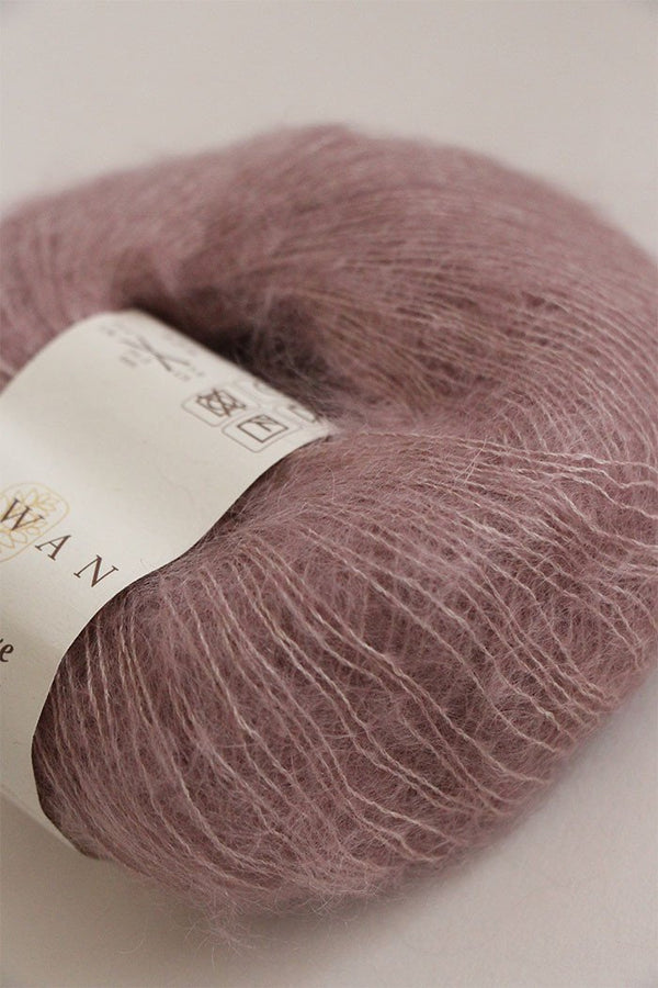 Close-up of Rowan Kidsilk Haze yarn in soft, multicolored strands, showcasing its lightweight, delicate texture for knitting or crochet projects.