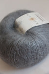 Close-up of Rowan Kidsilk Haze yarn in steel color, showcasing soft, delicate fibers perfect for knitting or crochet projects.