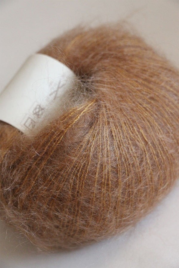Close-up of Rowan Kidsilk Haze yarn in fudge color, showing soft, delicate fiber with a slightly fuzzy texture.