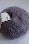 Close-up of Rowan Kidsilk Haze yarn in soft, blended colors, showcasing its delicate, fine texture ideal for knitting and crochet projects.