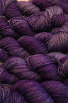 Fingering weight yarn by Zen Yarn Garden, Serenity 20 in pansies colorway, showcasing soft, variegated purple and yellow hues.