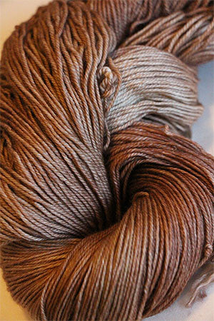 Fingering weight yarn from Zen Yarn Garden's Serenity 20 collection in a soft latte color, showing the yarn's texture and fiber details.