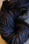 Fingering weight yarn Zen Yarn Garden Serenity 20 in moody, deep blue and gray tones, showcasing soft, textured fibers.