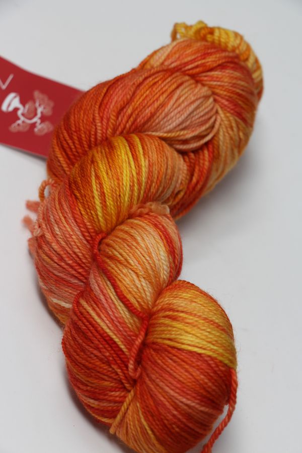 Fingering weight yarn from Zen Yarn Garden's Serenity 20 collection in a vibrant, crush-colored skein with soft, textured fibers.