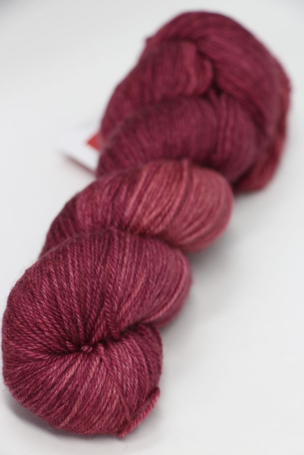 Fingering weight yarn from Zen Yarn Garden's Serenity 20 collection in a soft blush color, showcasing smooth, high-quality fiber.