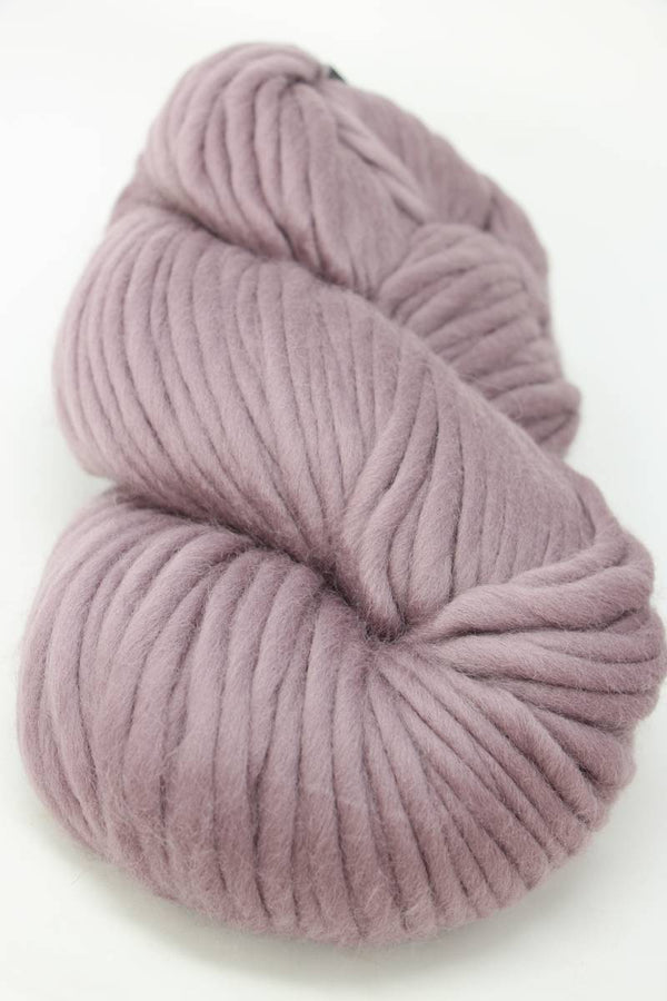 Cascade Yarns Magnum bulky yarn in elderberry purple, showing thick, textured skein suitable for cozy knitting projects.