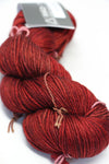 MadelineTosh vintage merino wool yarn in cardinal red color, soft and textured for knitting or crochet projects.