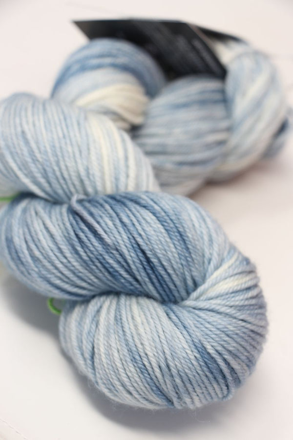 Cream-colored madelinetosh VINTAGE Merino Wool Yarn in whitewash shade, soft and textured for knitting or crochet projects.