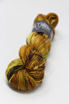 Soft yellow Madelinetosh Tosh DK yarn in a skein, showcasing its smooth texture and vibrant color for knitting or crochet projects.