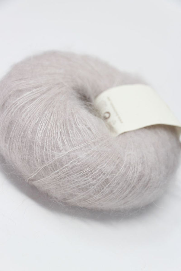 Soft Rowan Kidsilk Haze yarn in pearl color, showing delicate, lightweight silk and mohair fibers ideal for knitting or crochet projects.