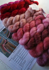 Artyarns Silk Mohair Blanket Knitting Kit with pink and rose-colored yarns, displayed with knitting needles and pattern instructions.