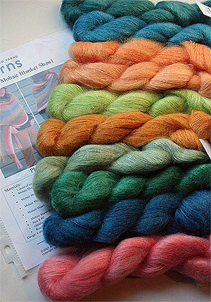 Artyarns Silk Mohair Blanket Kit with blue yarns and knitting supplies for cozy handmade blanket creation.
