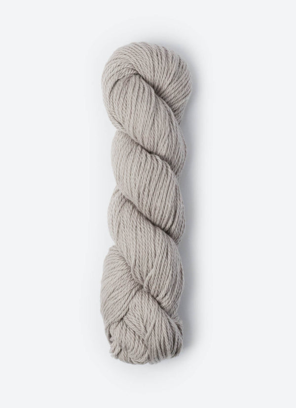 Blue Sky Fibers Sweater Worsted Superwash knitting yarn in blue, with soft wool and cotton blend texture and label visible.