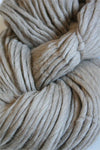 Cascade Yarns Magnum bulky yarn in a soft heathered beige color, displayed in a close-up shot highlighting its thick texture.