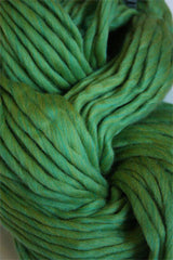 Cascade Yarns Magnum bulky yarn in lime green, showing thick, soft yarn strands perfect for cozy knitting projects.
