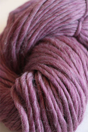 Cascade Yarns Magnum bulky yarn in a soft mulberry flurry color, shown in a close-up of the textured fiber strands.