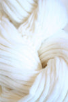 White Cascade Yarns Magnum bulky yarn ball, showcasing soft, thick fiber for knitting or crochet projects.