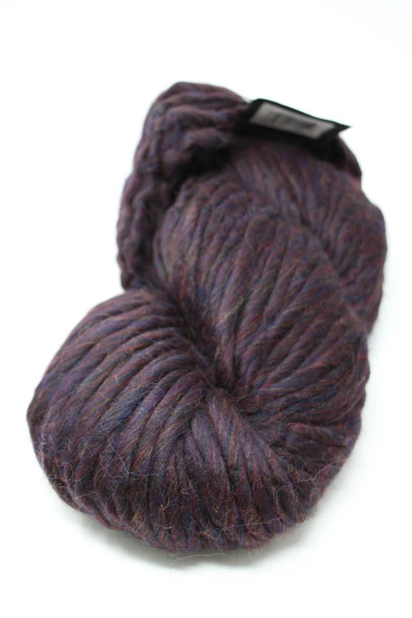 Brightly colored Cascade Yarns Magnum bulky yarn ball with a galaxy-inspired pattern, showcasing vibrant purple, pink, and blue hues.