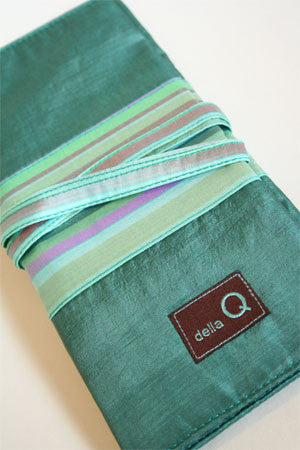 Della Q interchangeable needle case in seafoam with compartments for knitting needles and accessories.