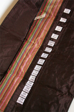 Della Q interchangeable needle case holding multiple knitting needles in black with clear compartments for organization.