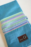 Della Q interchangeable needle case holding sewing needles, with a sleek, compact design in neutral colors.