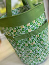 Della Q Yarn Cleo & Tess knitting bag with colorful woven pattern and leather handles, designed for organizing knitting supplies.