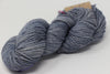 Madelinetosh Tosh DK yarn in Aura color, showing soft, twisted wool skein with rich blue and gray tones.