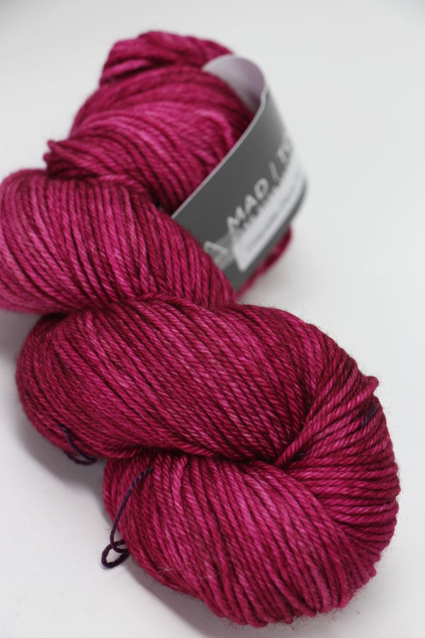 Madelinetosh Tosh DK yarn in Coquette Deux, showing soft pink and purple tones with a smooth, twisted skein.