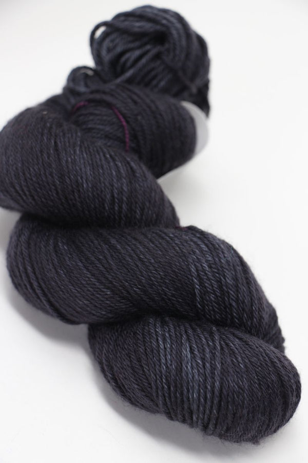 Madelinetosh Tosh DK yarn in Dirty Panther color, showing soft wool skein with rich dark green and black tones, close-up shot.