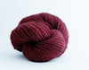 Soft Madelinetosh Tosh DK yarn in a vibrant heartbeat colorway, showcasing its smooth texture and rich, variegated hues.